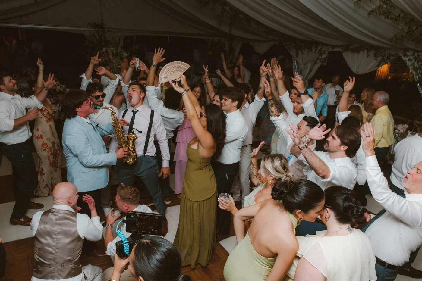 Packed wedding dance floor with guests dancing
