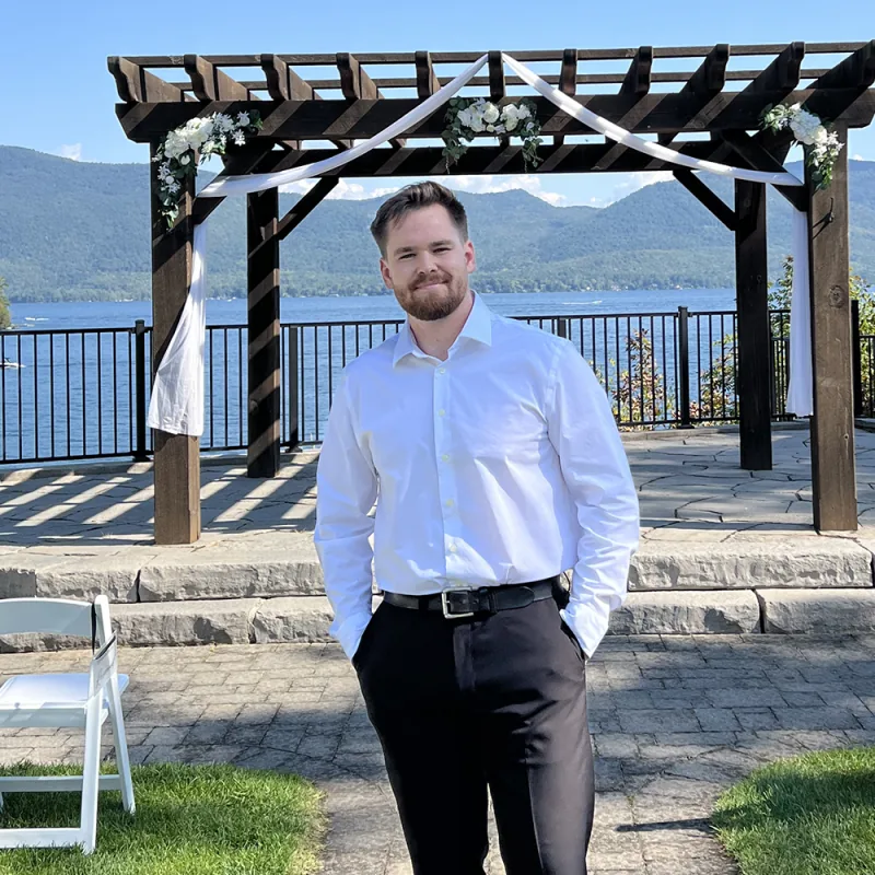 Corey of VARA DJs standing at a lakeside wedding ceremony site
