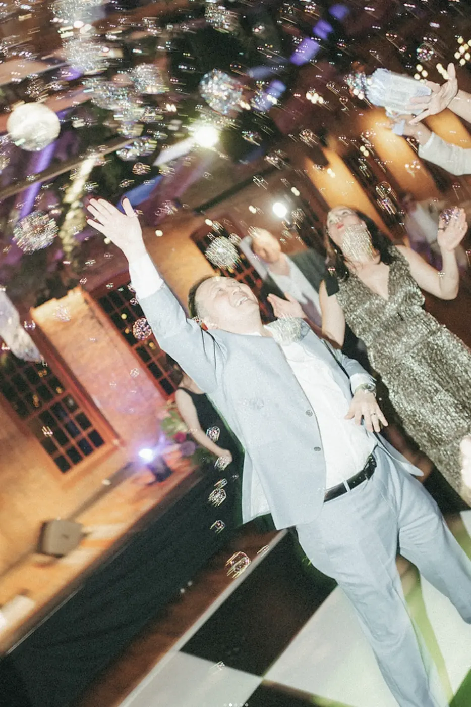 Wedding guests dancing under party lights at a reception