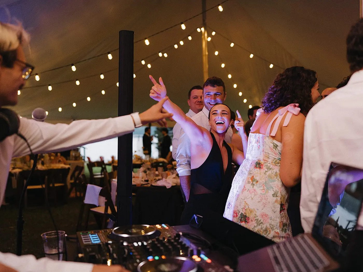 Justin DJing a tented wedding reception while guests dance