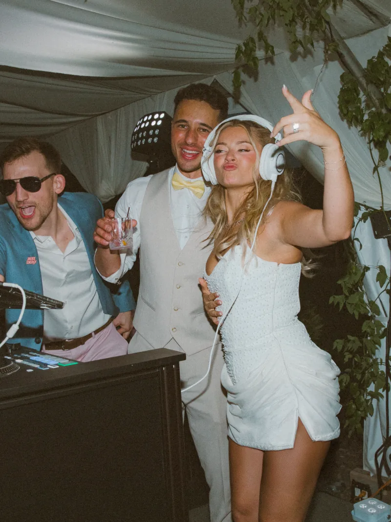 Guests dancing beside the DJ booth at a wedding reception
