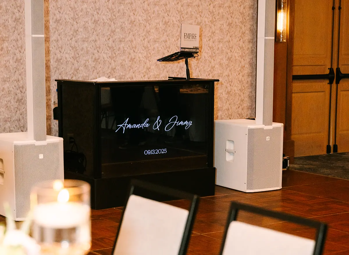 Wedding DJ booth with a personalized front panel and two column speakers