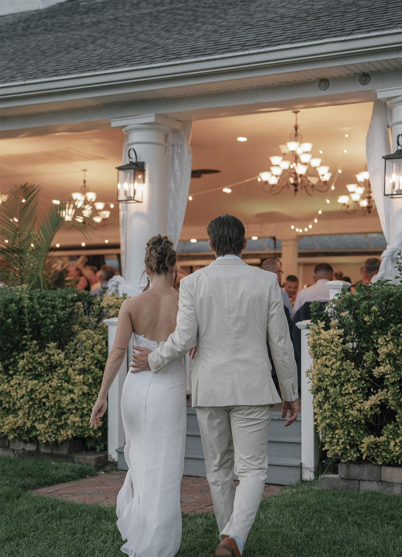 A newlywed couple walks into their wedding reception as guests await an unforgettable evening with professional wedding DJ and MC services by VARA DJs.