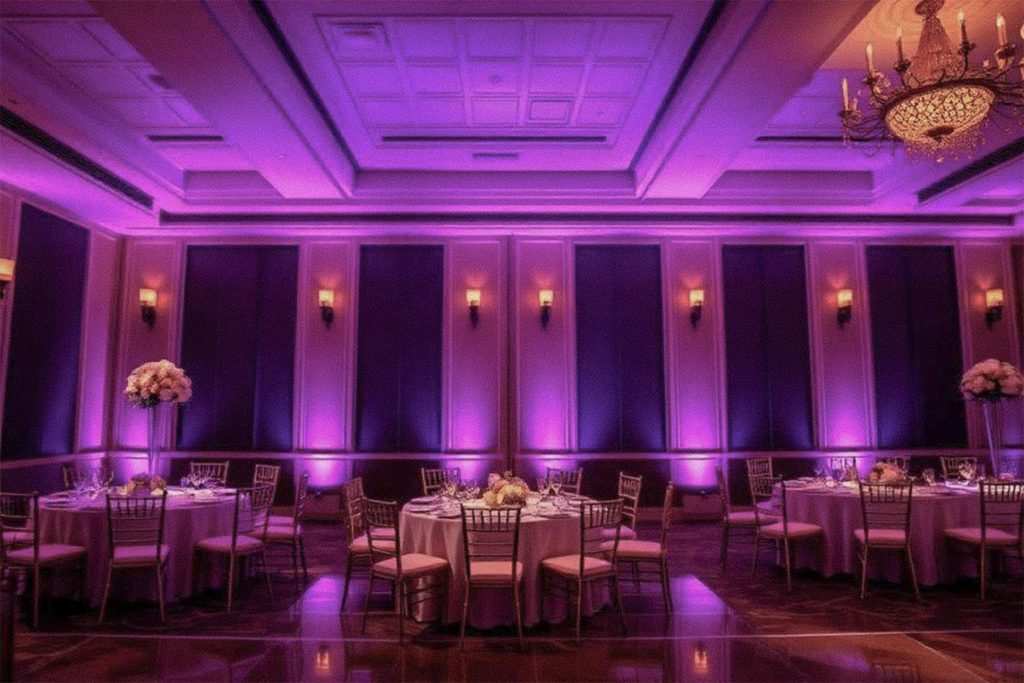 Professional LED uplighting enhances a wedding reception venue with customizable colors and elegant ambient lighting by VARA DJs.