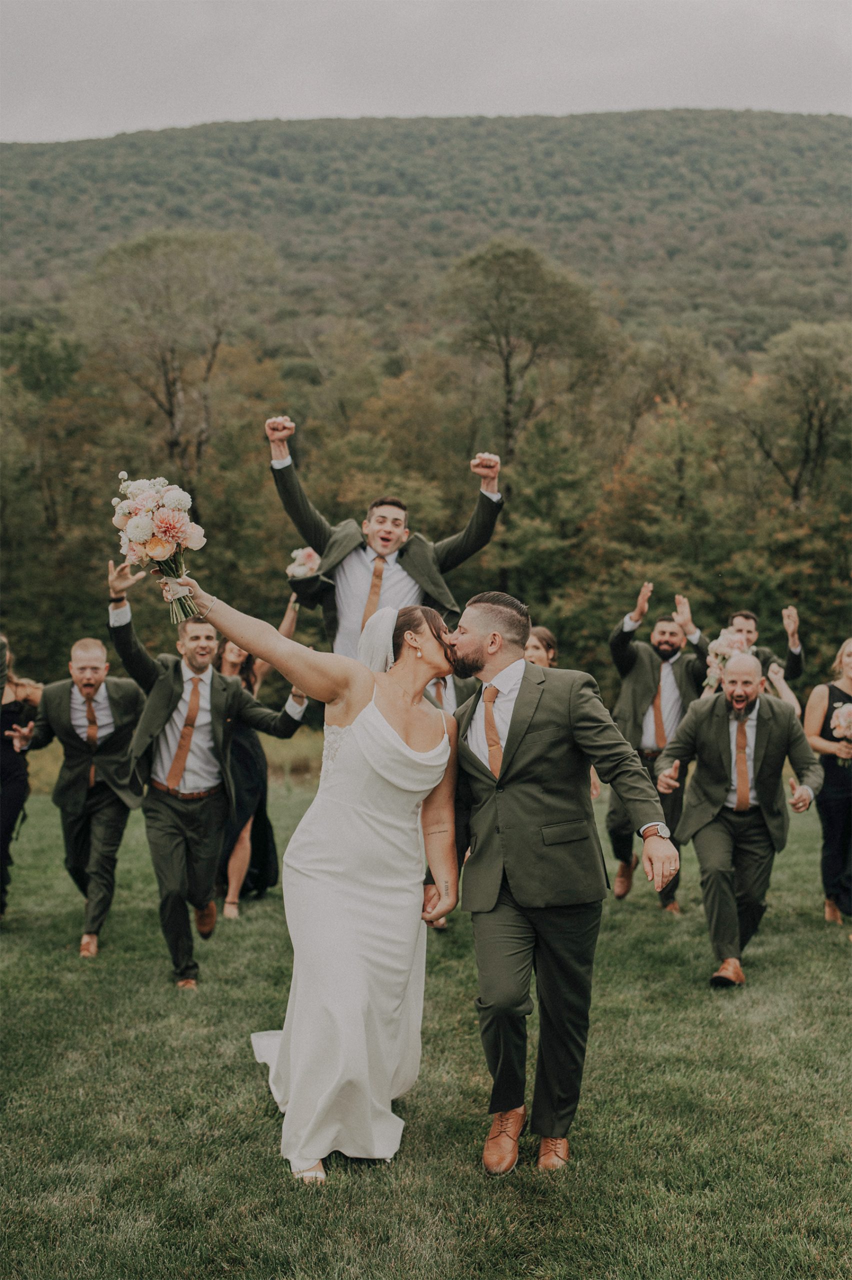 A newlywed couple celebrates with their wedding party outdoors after the ceremony, creating unforgettable memories with a reception hosted by VARA DJs.